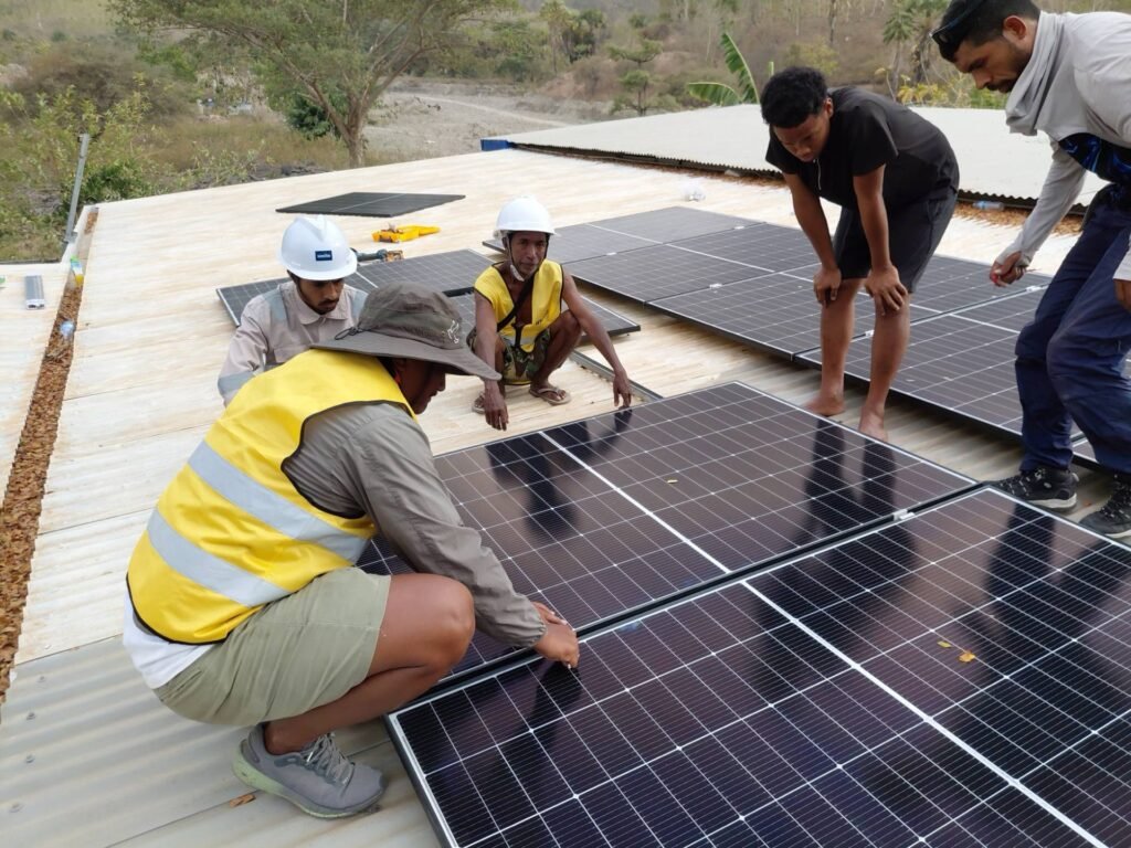 GoKoval installers working with community members on a rooftop